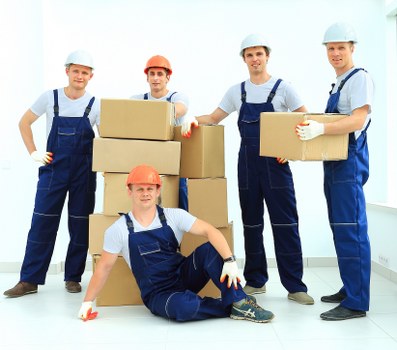Staff using PPE and safe handling techniques during a house removal